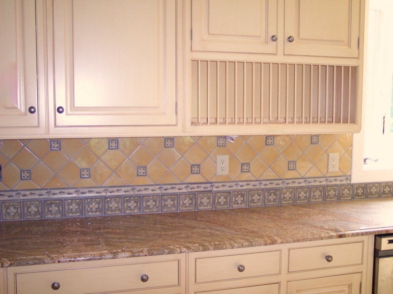 Patterned tile backsplash running the length of a granite counter