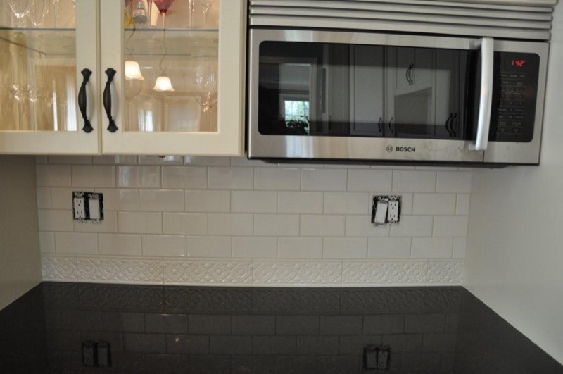White subway tile backsplash with a decorative chair rail course