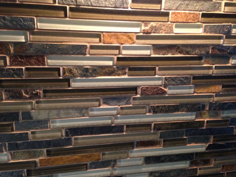 Close-up of a linear glass and slate mosaic tile backsplash