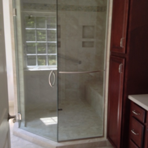 Neo-angle glass shower enclosure with tiled walls and niches